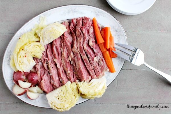 Corned Beef and Cabbage Recipe on a vintage white plate with boiled potatoes and carrots on either side