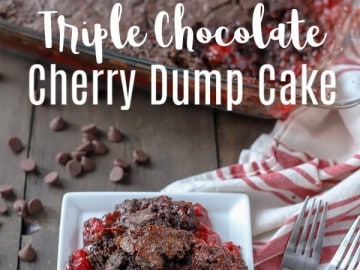 triple chocolate cherry dump cake on a white plate with forks to the right and chocolate chips and the rest of the dump cake in a baking dish behind it