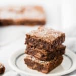 quick and easy brownies stacked up 3 high on a white plate