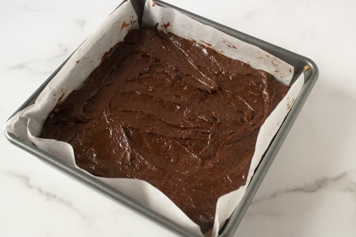 the peanut butter and chocolate mixtures are evenly spread on a baking sheet with parchment paper ready to be cooked