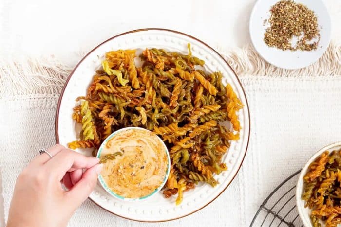 gluten-free pasta chips cooked in an air fryer witha zesty tahini sauce