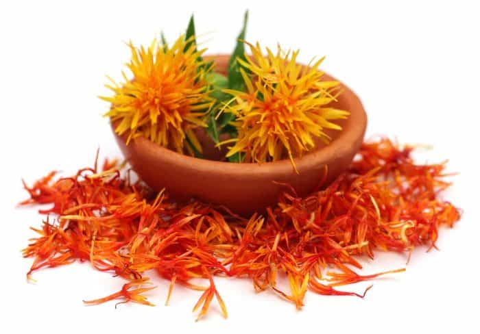 Safflower in a bowl over white background