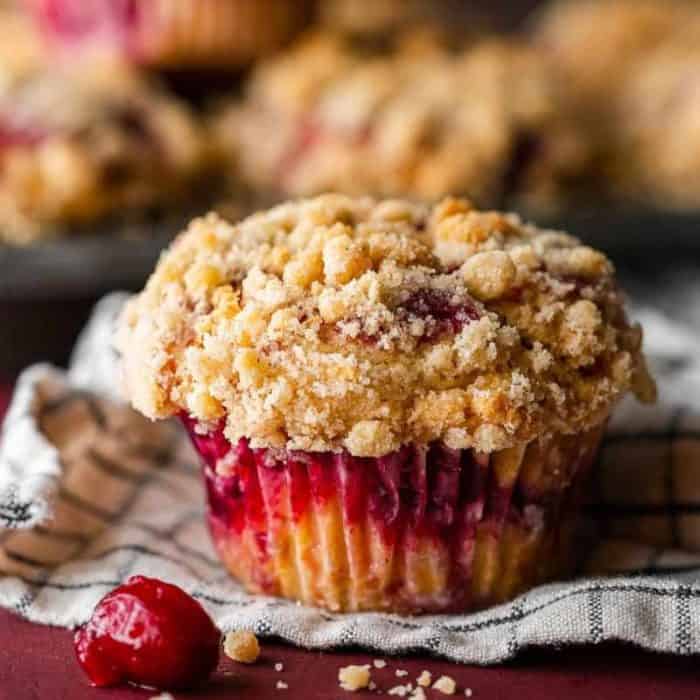 These delightful bakery-style coffee cake muffins are layered with cranberry sauce and topped with a sweet buttery crumble.