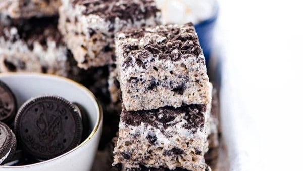 a close up image of guilt free cookies and cream rice krispie with real oreos on the side