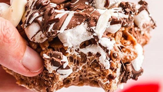 a person holding a piece of Cocoa Krispies are a fantastic combination of chocolate and crispy rice treats. 