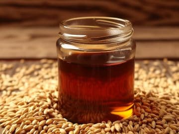 realistic image of a barley malt syrup in a jar for jams in the kitchen with barley seeds on the sides