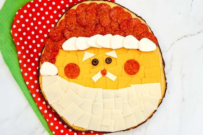 Christmas charcuterie board with Santa's face featuring pepperoni and an assortment of cheeses