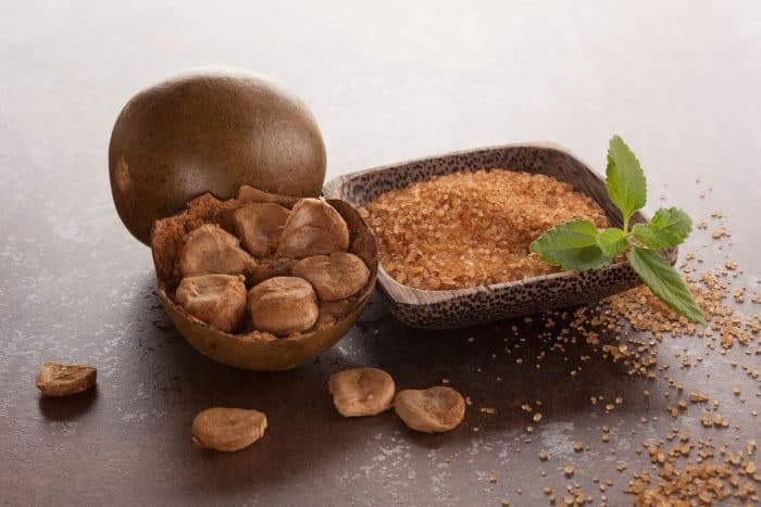 Luo Han Guo aka Monk fruit natural herbal remedy and sugar on brown background.