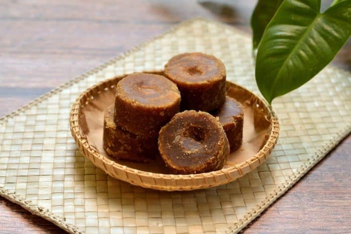 Organic brown palm sugar or coconut sugar, better known as Java sugar on a rattan plate