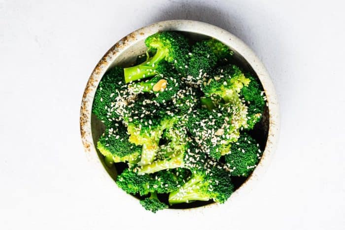 Korean broccoli salad with bright green broccoli florets tossed in a garlicky sesame dressing and sprinkled with sesame seeds