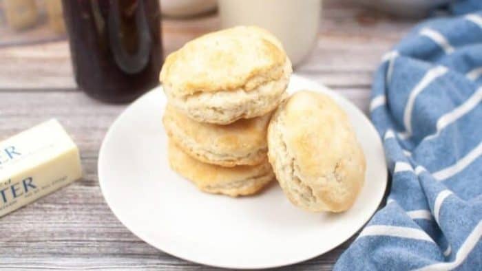These delicious and straightforward sourdough discard biscuits on a white plate are a perfect match for a hearty stew or a warm meal. 