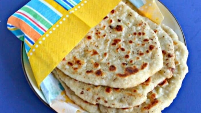 fluffy Naan placed on a colorful napkin and on a table 
