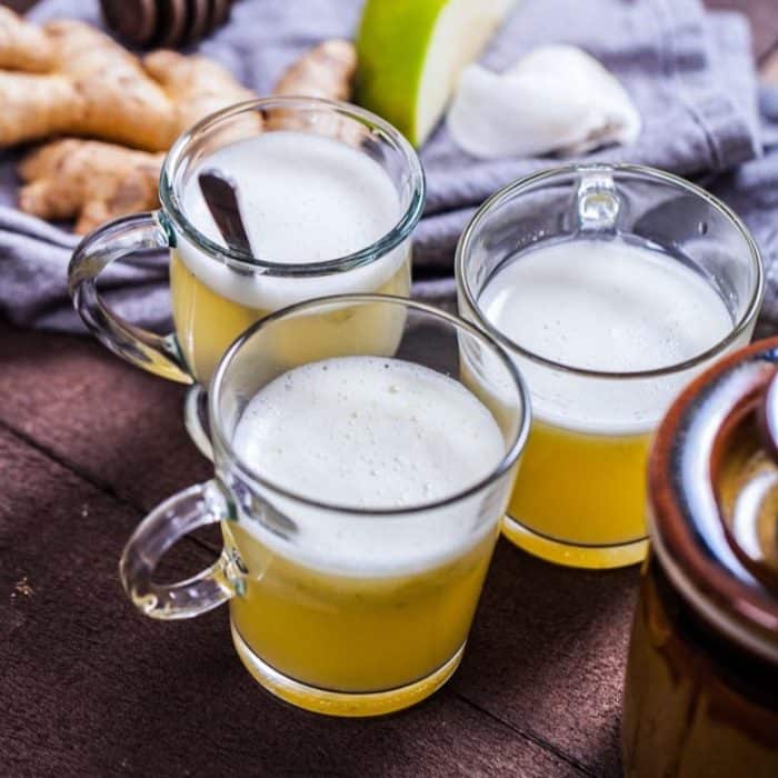three wellness shots placed on a table Each shot contains lemon