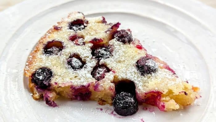 The blueberry skillet cake is a testament to simplicity and flavor, with plump blueberries dotting a moist, tender cake that's baked to perfection in a skillet.
