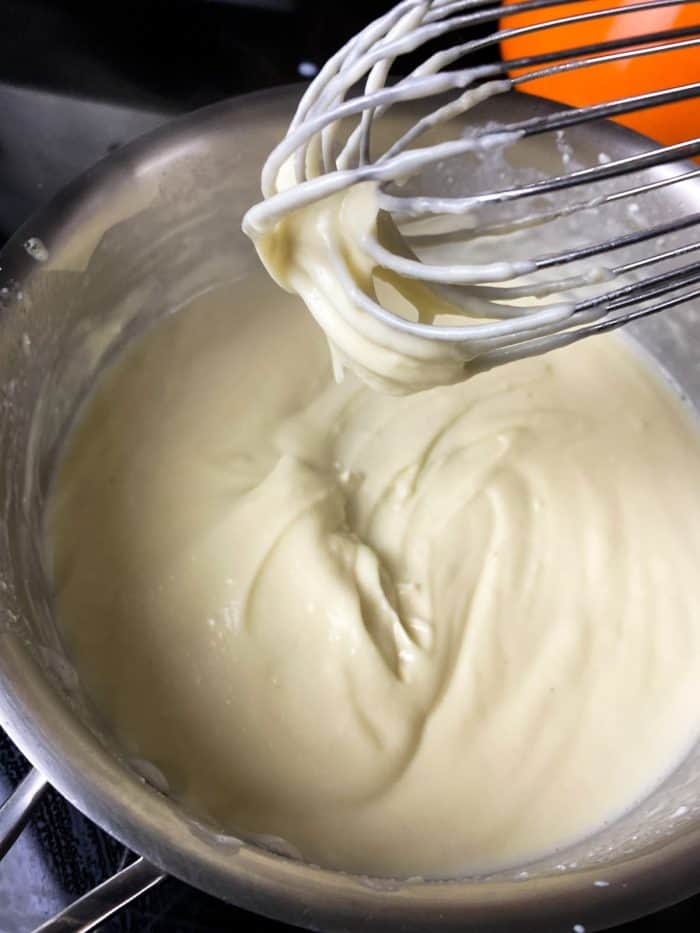 whisking the sauce on a mixing bowl
