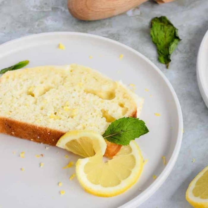 this homemade loaf sings with the zest of fresh lemons and the richness of Greek yogurt, all topped with a sweet glaze