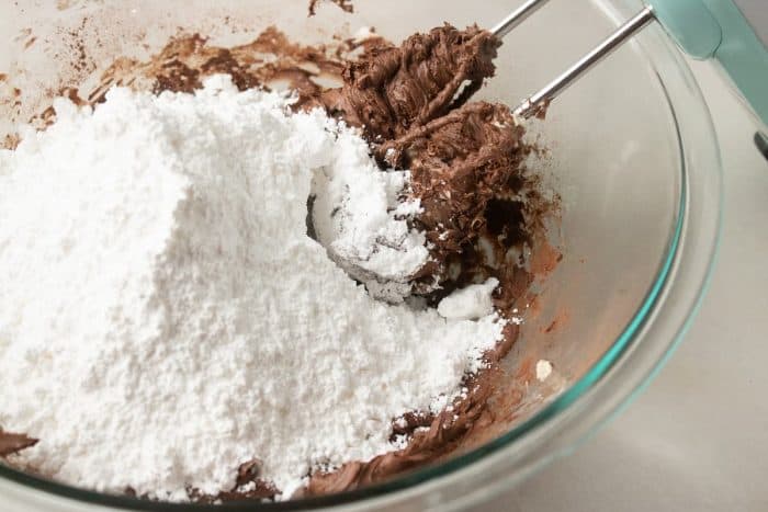 Gradually mix in 16 ounces of powdered sugar at low speed to achieve a dense and rich consistency.
