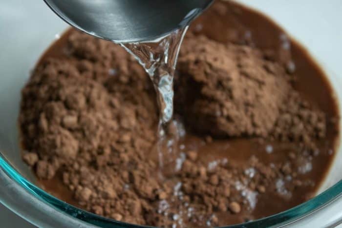 stir the cocoa powder into boiling water until it's fully dissolved in a smooth mixture.
