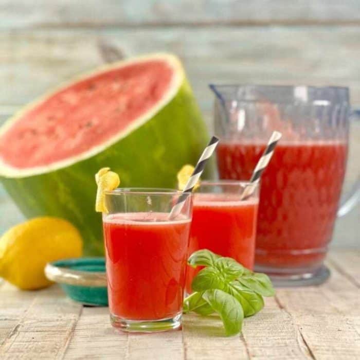 For a detox that feels like a treat, try this sweet watermelon juice placed on a wooden table with real watermelon on the background