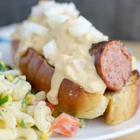 This grilled beer kielbasa recipe features Polska kielbasa smothered in a delicious sauce made with sausage, Guinness extra stout beer, and cheese and nestled in a soft bun.