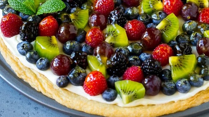 palate on this vibrant and refreshing fruit pizza, which has a sugar cookie crust, a luscious cream cheese frosting, and a mosaic of fresh, juicy fruit
