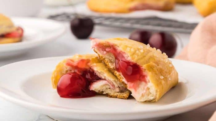 The golden, flaky exterior of these pastry pockets encases a creamy, sweet cherry cheesecake filling for a handheld dessert