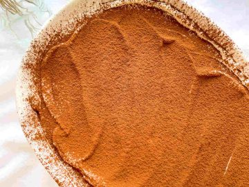 a close up photo of espresso tiramisu in a tub