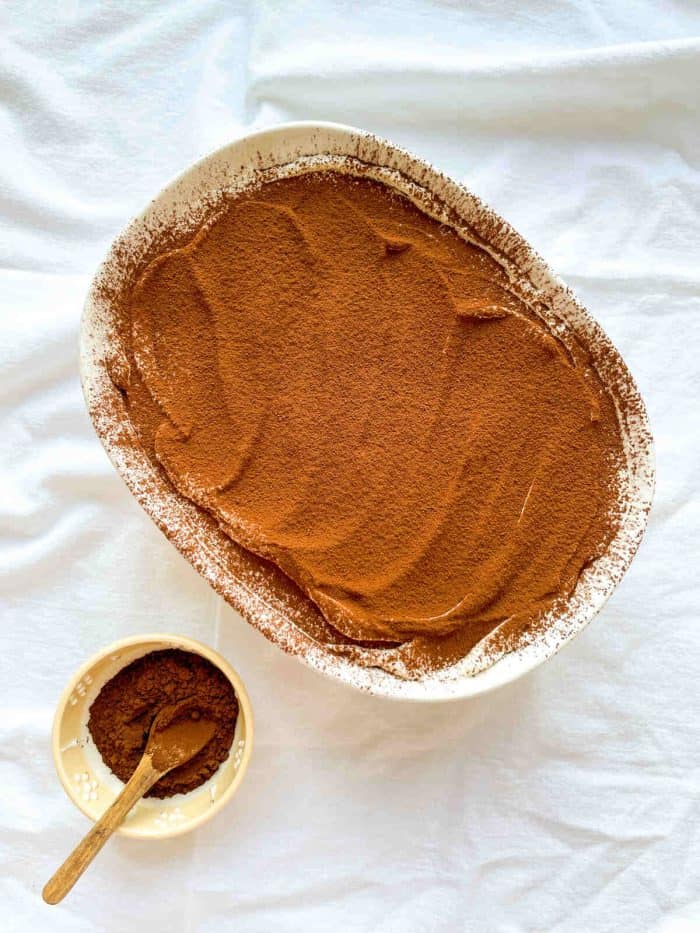 a casserole with espresso tiramisu dusted with unsweetened cocoa powder