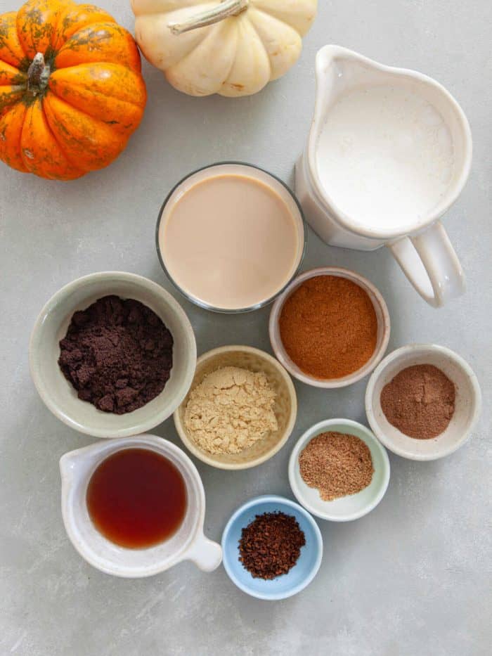 complete ingredients of pumpkin spice irish coffee on a white table