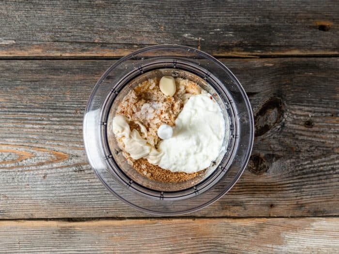 While the calamari marinates, prepare the dressing by combining breadcrumbs, almonds, garlic, lemon juice, olive oil, yogurt, and mayonnaise in a food processor.