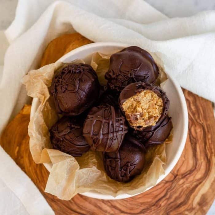 These no-bake morsels are loaded with the protein-rich goodness of chickpeas, sweetened naturally with maple syrup and brown sugar, and coated in melted dark chocolate to satisfy your craving for cookie dough.  
