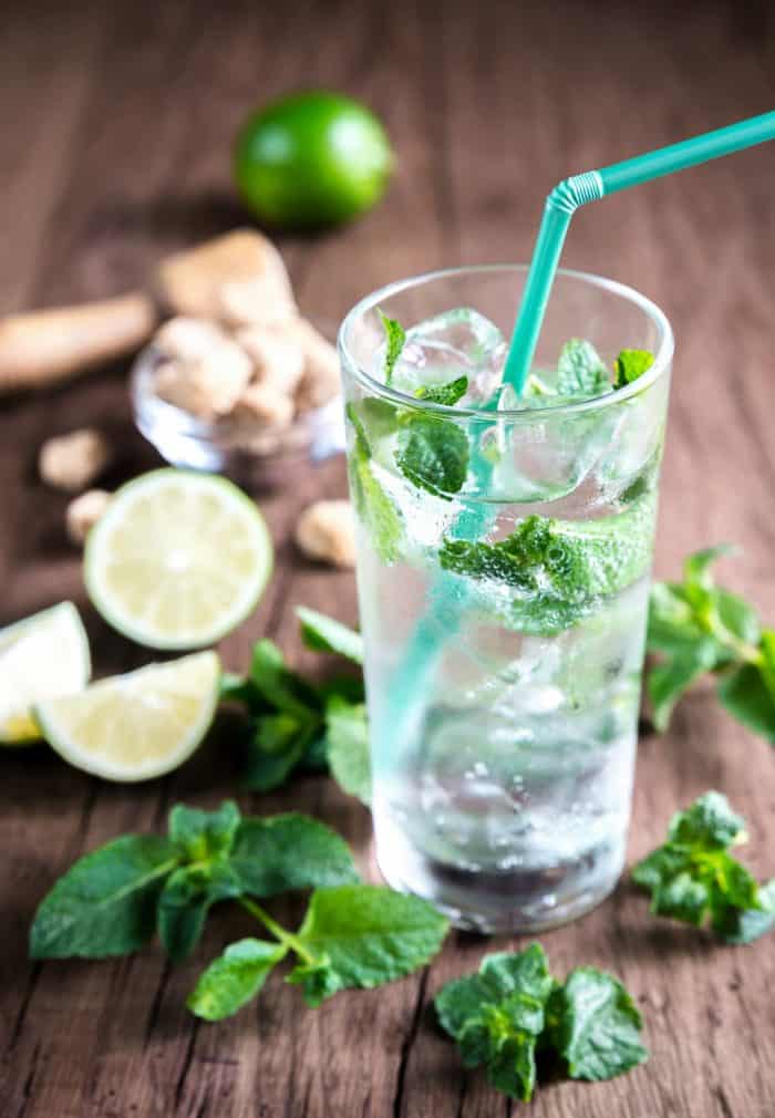 Glass of mojito with ingredients on a wooden table