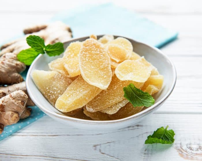 Sweet and spicy candied ginger on a old white wooden table
