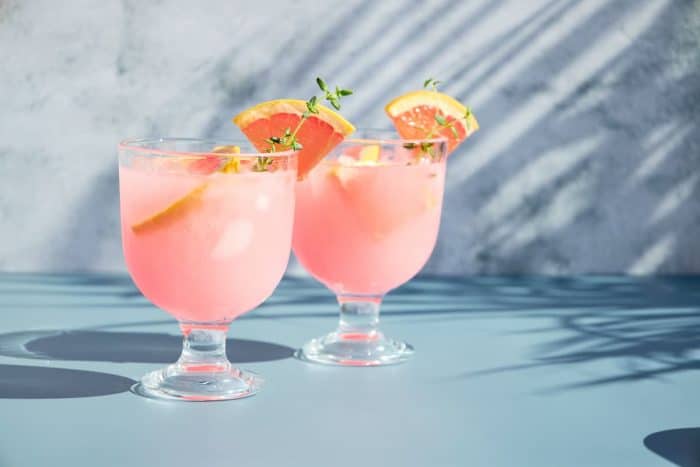 Cold drinks with citrus fruits on a bright sunny day in the shade of palm trees.