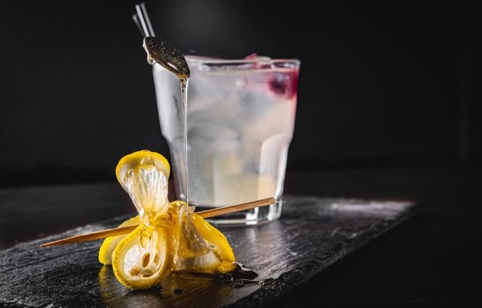 Gin Cocktail with Lemon and honey on black background