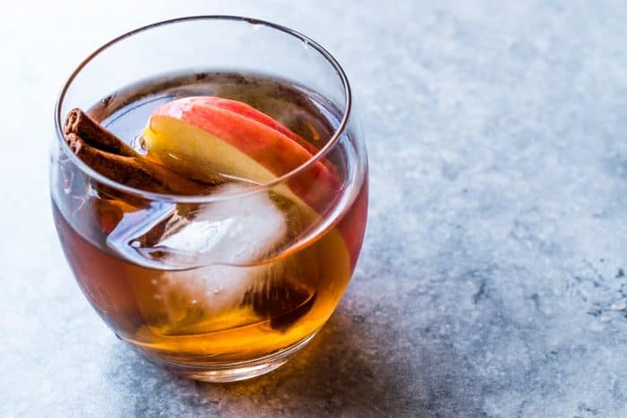 Apple Cider Whiskey Cocktail with Cinnamon Sticks, Ice and Apple Slices