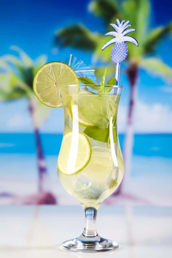 a glass of citrus cocktail with slices of lime