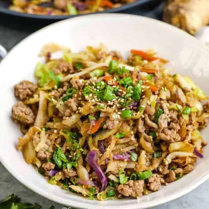 a white bowl filled  with egg roll