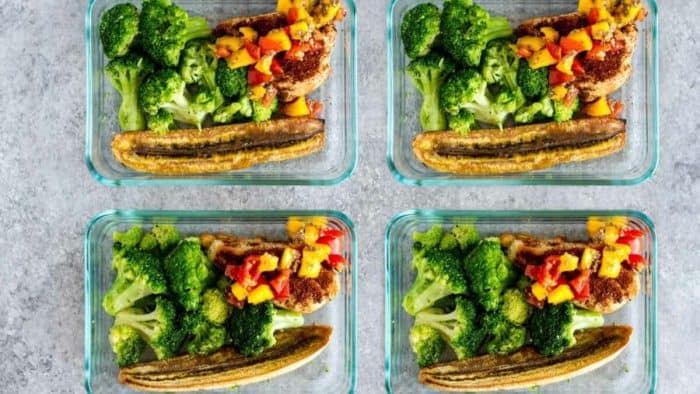four lunchboxes full of jerk chicken meal prep bowls