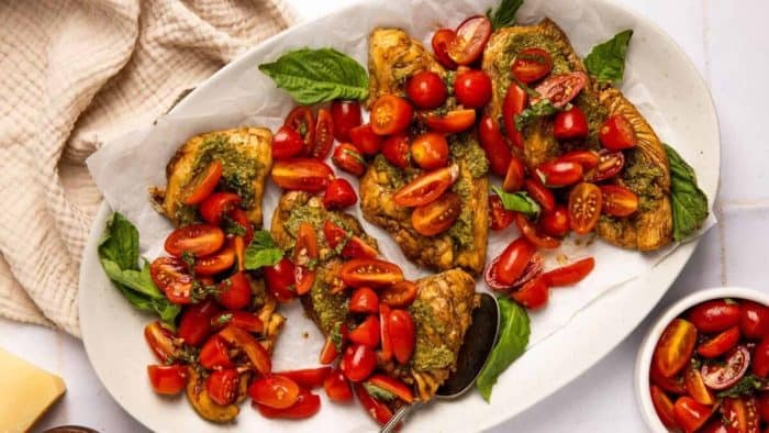 an oval plate filled with  pesto bruschetta chicken 