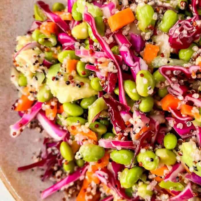 a close up photo of quinoa edamame salad on a plate