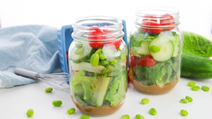 two jars filled with Garden Salad With Sweet and Spicy Apple Dijon Dressing