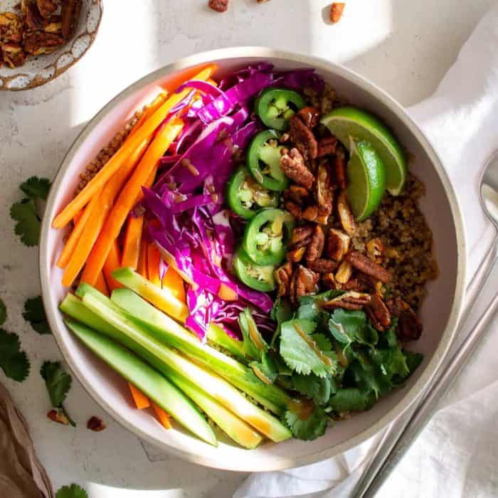 a bowl full of quinoa veggie bowl with spoon on the side