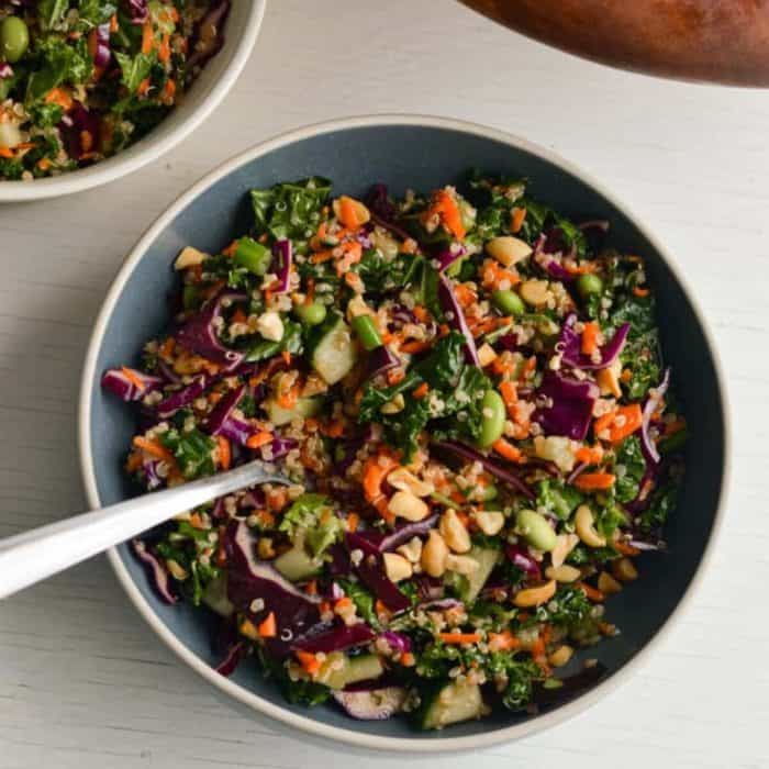 a round plate full of thai chopped salad with spoon on it