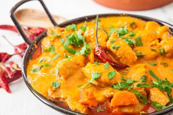 a casserole of red curry topped with red chili