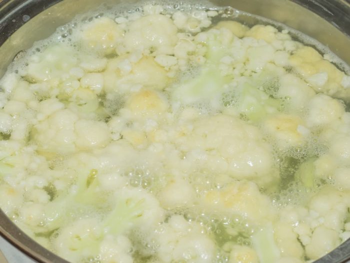 Boiling cauliflowers and potatos in large metal pot.