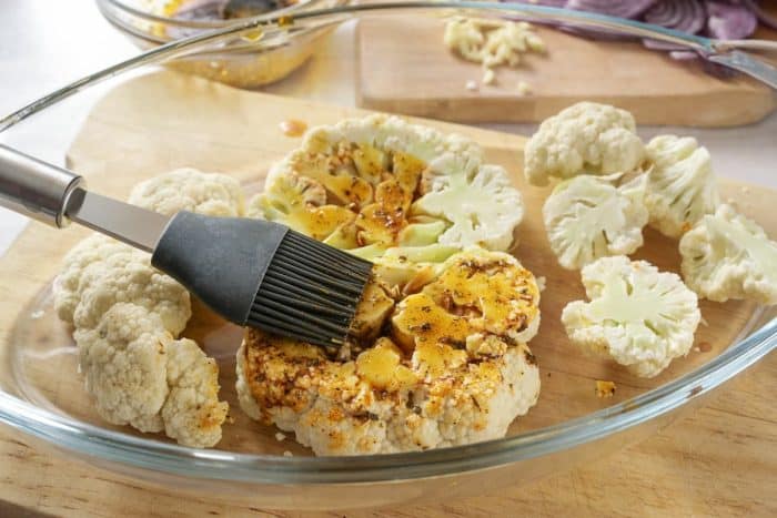 Take a pastry brush and coat the cauliflower steaks generously with the prepared honey sriracha glaze.