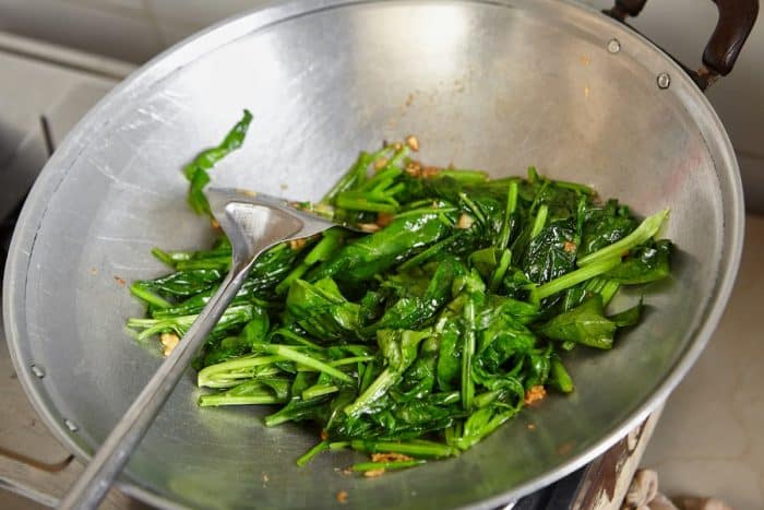 While the steaks are in the oven, heat a small amount of olive oil in a pan over medium heat and sauté the spinach until it wilts and becomes tender.
