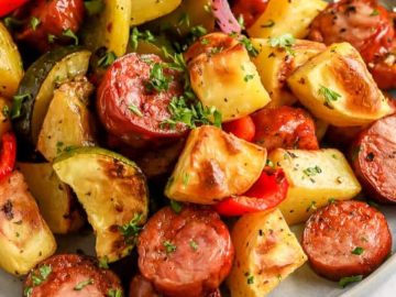 a close up photo of roasted sausage and potatoes on a plate