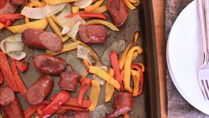 a photo of baked sausage and peppers on a pan
